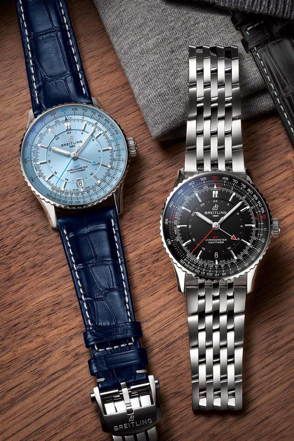 Navitimer with a light blue dial and Navitimer with a black dial on a table.