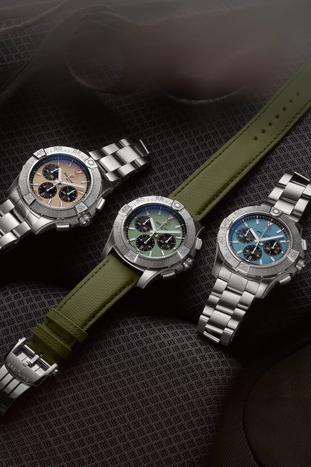 Three Avengers with different colored dials rest on black seats.