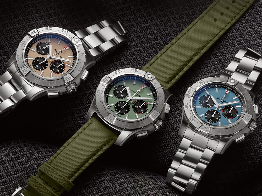 Three Avengers with different colored dials rest on black seats.