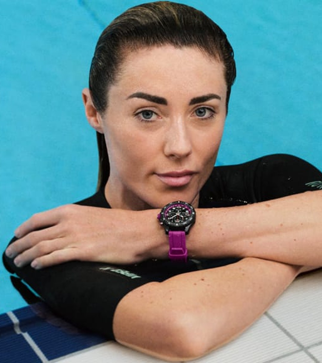 a woman leaning against a wall in a swimming pool