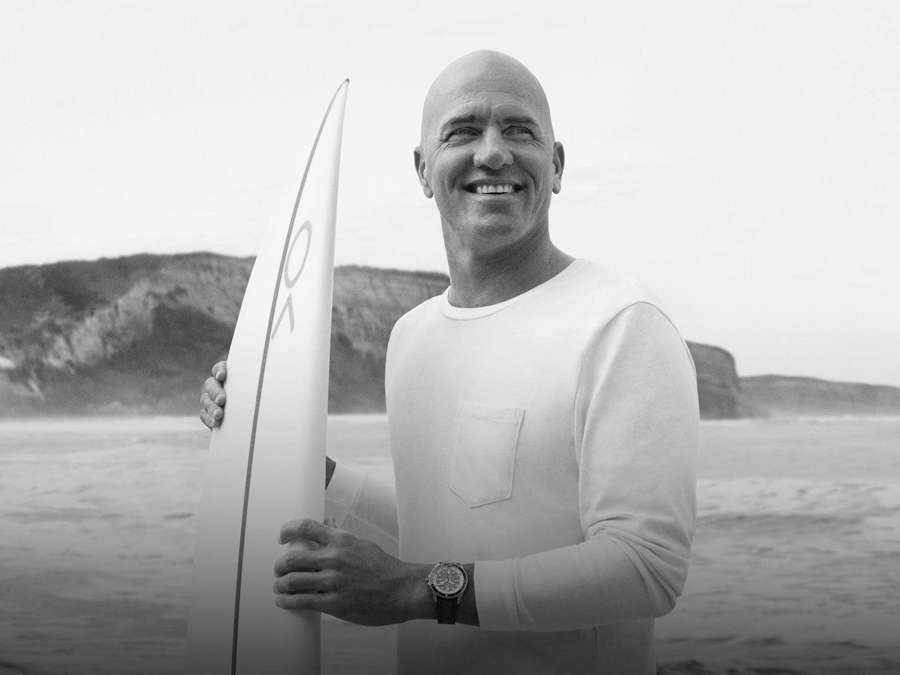 a man holding a surfboard on the beach