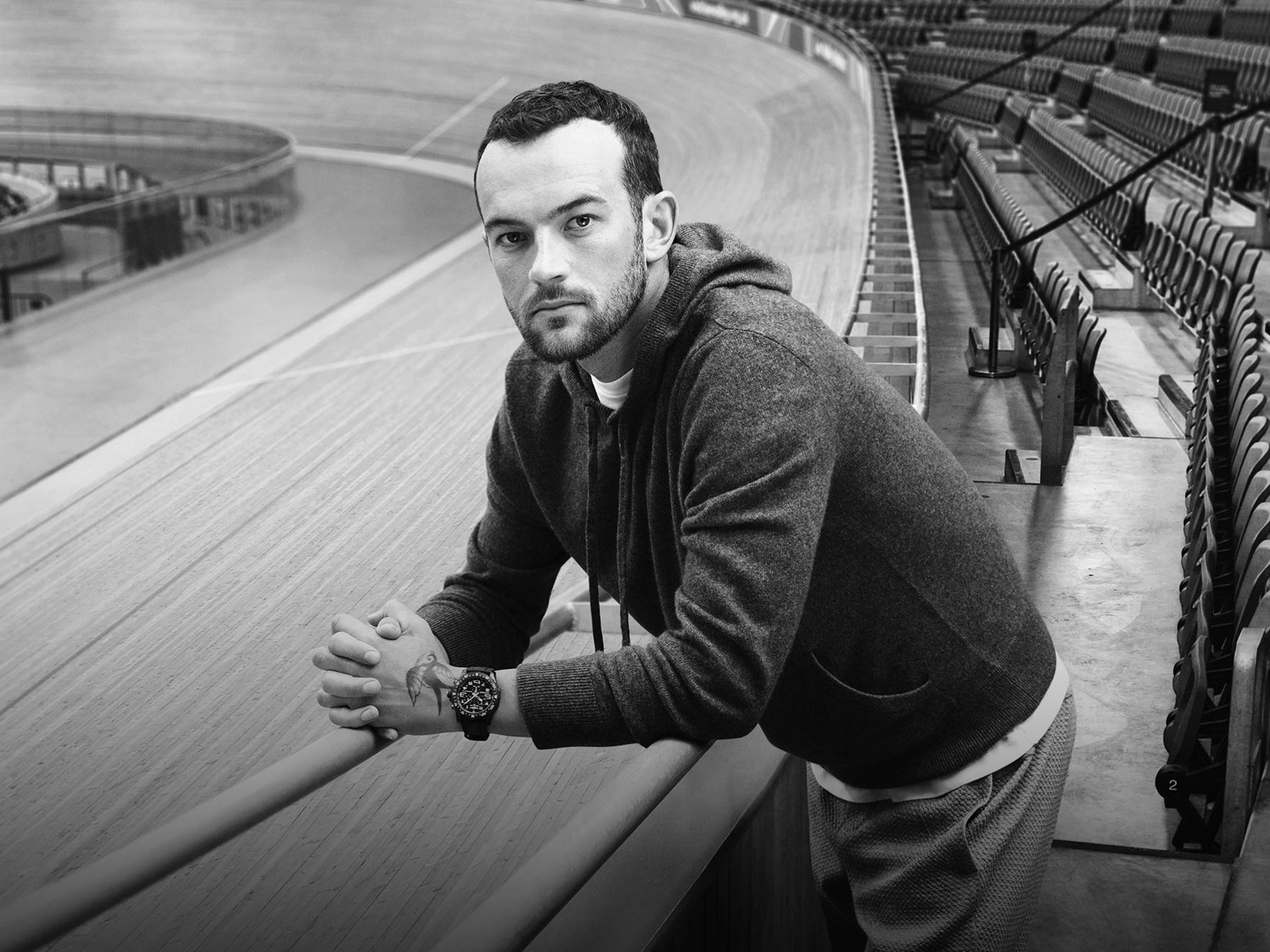 a black and white photo of a man leaning on a railing