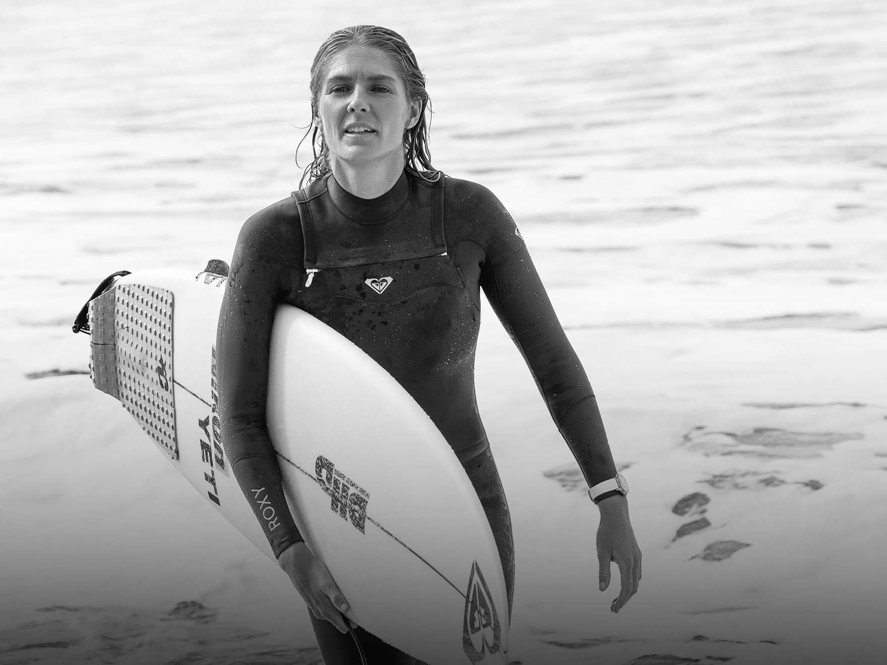 a woman holding a surfboard on a beach