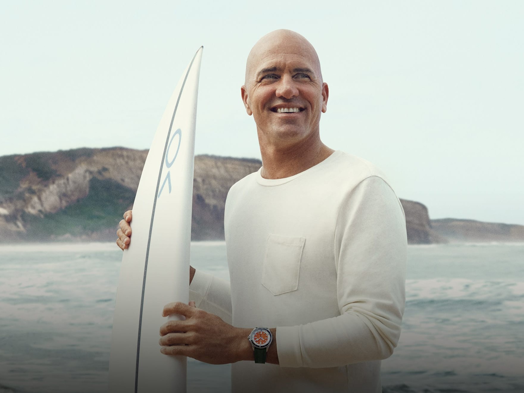 a man holding a surfboard on the beach