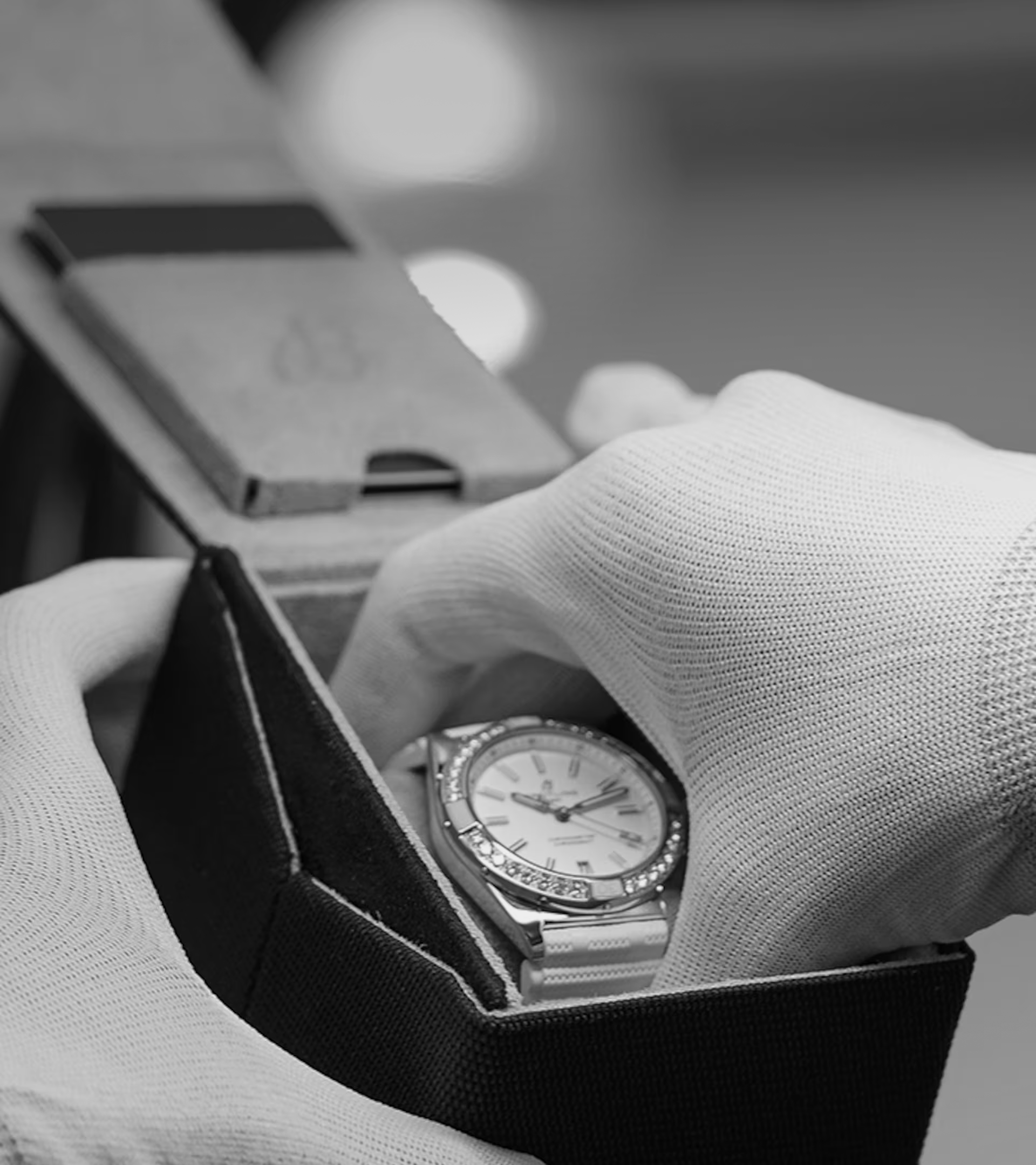 Carefully and with gloves on, a Breitling watch is taken out of its packaging.