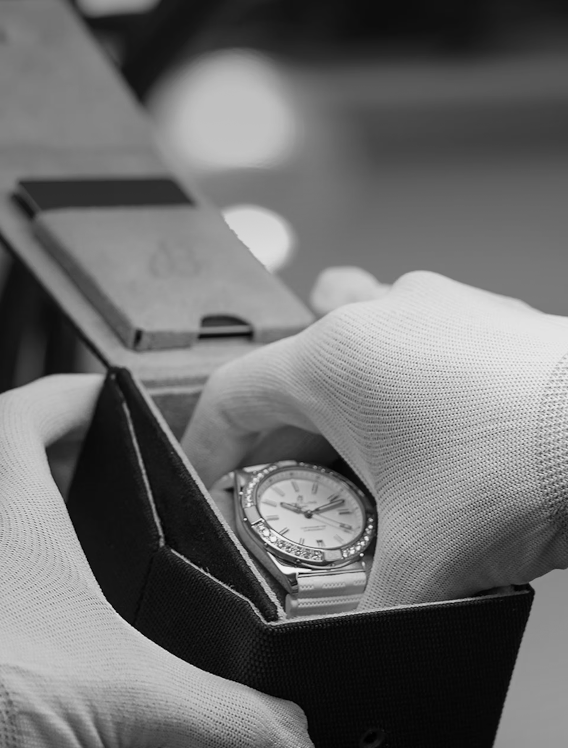 Carefully and with gloves on, a Breitling watch is taken out of its packaging.