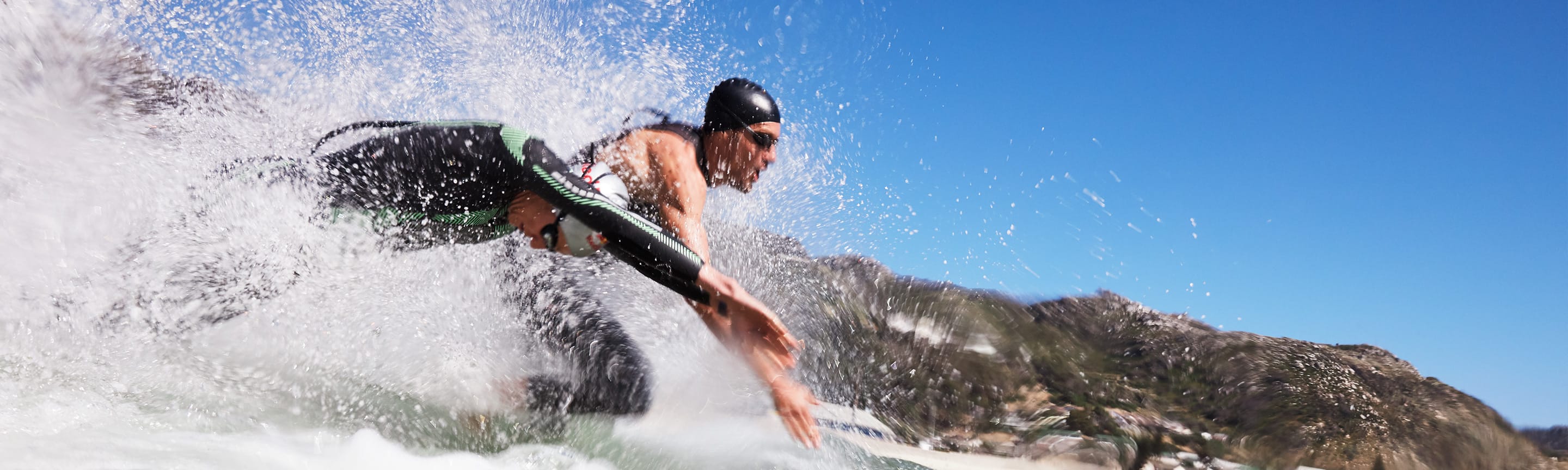 Two Ironman athletes, symbolizing the partnership between Breitling and Ironman, jump into the water.