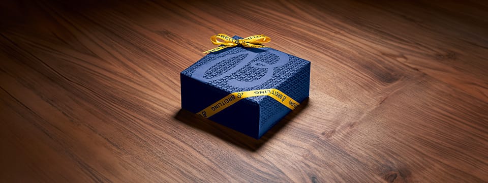 a blue gift box on a wooden floor