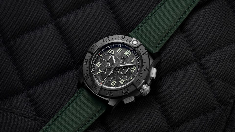 a watch on a black background with green straps